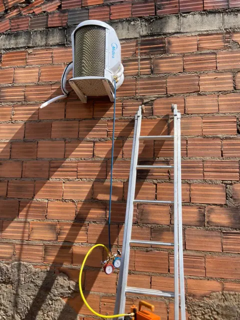 Condensadora de ar-condicionado instalada em parede com escada e manifold durante serviço em Palmas–TO