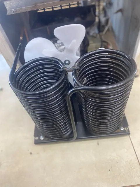Conjunto de serpentina e ventilador de refrigeração sobre bancada de oficina