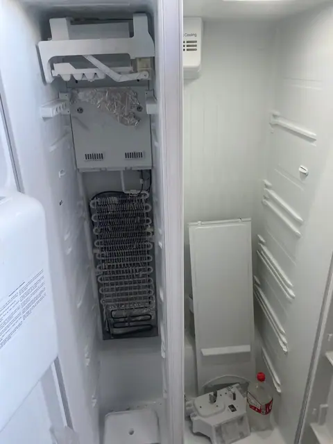 Interior de refrigerador com evaporador aparente durante atendimento técnico
