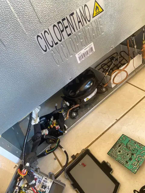 Parte inferior de geladeira aberta com compressor à vista em Palmas–TO