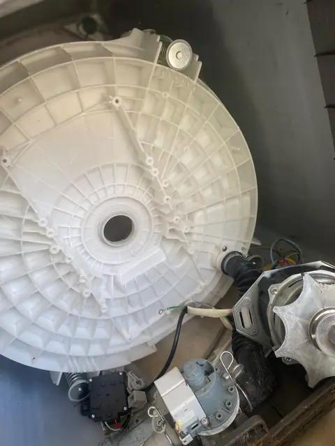 Tanque de máquina de lavar e motor durante serviço técnico